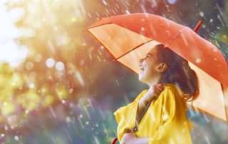 Laughing girl holding an umbrella in the rain