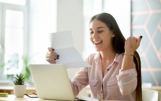 woman happily looking at a bill.