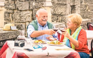 An older couple eating at a restaurant while on holiday.