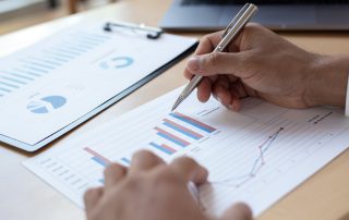 A person reviewing graph data on paper.