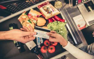 A customer handing over a bank card to pay for goods in a supermarket.