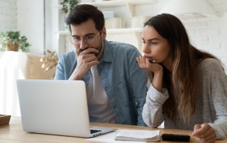 A couple looking at a laptop.