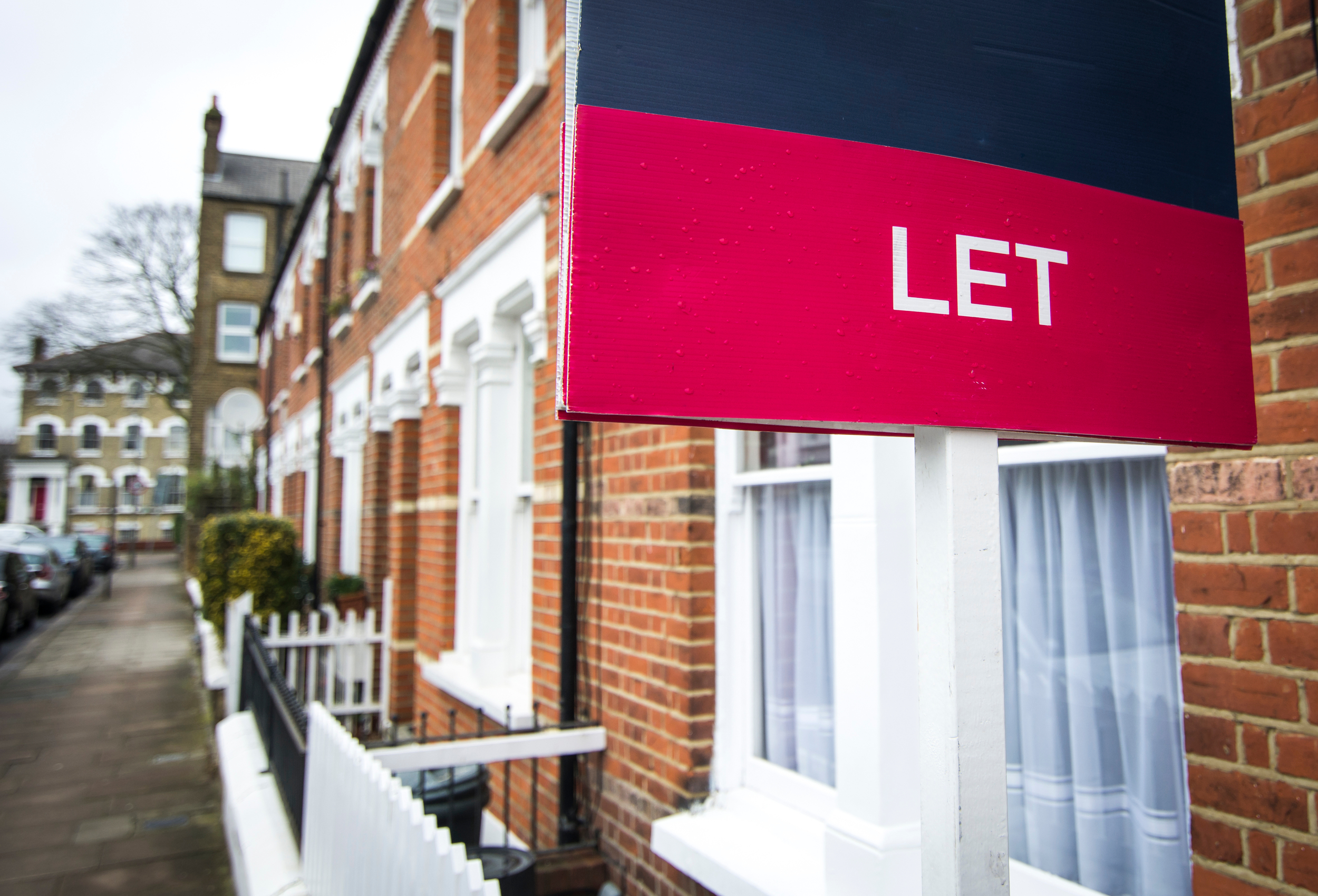 A “let” sign outside terraced houses.
