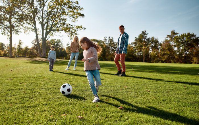 A family playing football in a park.