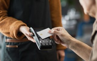 A person paying in a cafe using a contactless card.