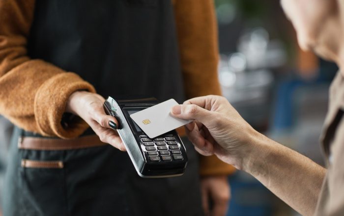 A person paying in a cafe using a contactless card.