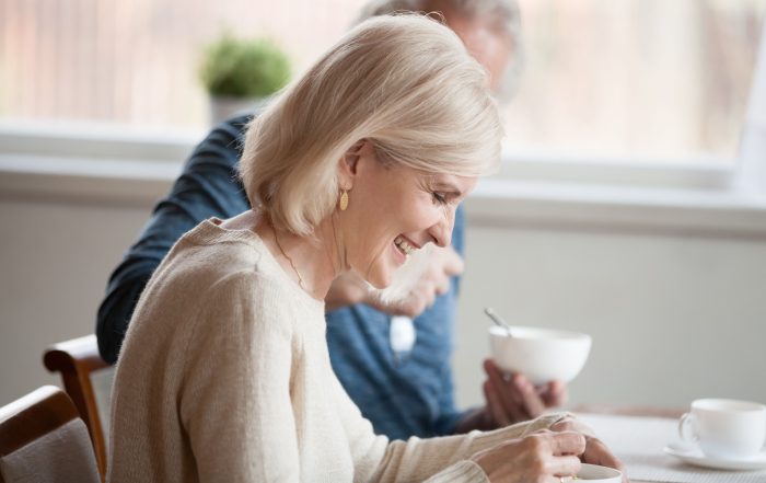 A mature couple talking while eating breakfast.