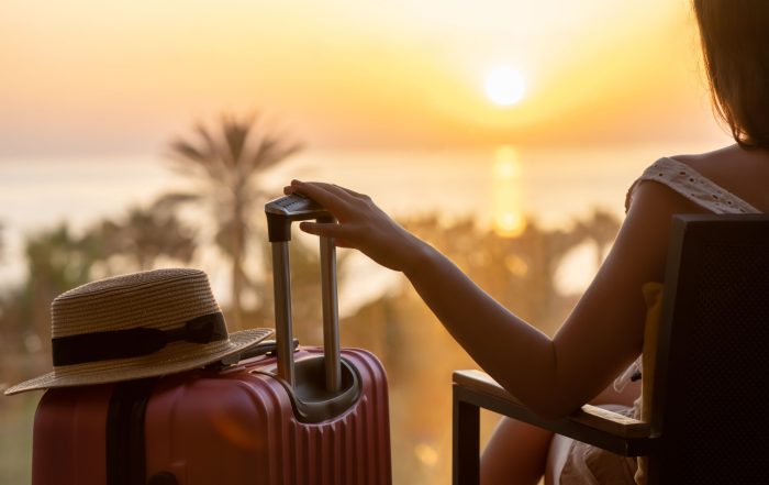A woman sitting with a suitcase.