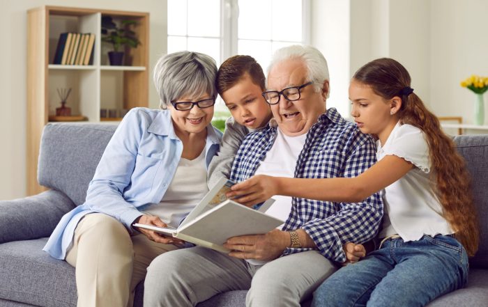 Grandparents looking at a photo album with their grandchildren.