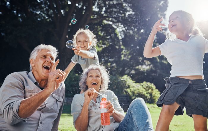 Grandparents blowing bubbles with their grandchildren.