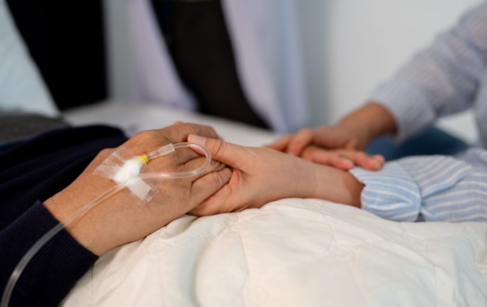 A patient holding hands with a loved one.