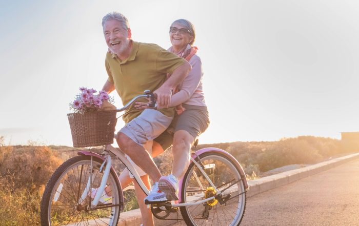 An older couple riding a bike together.