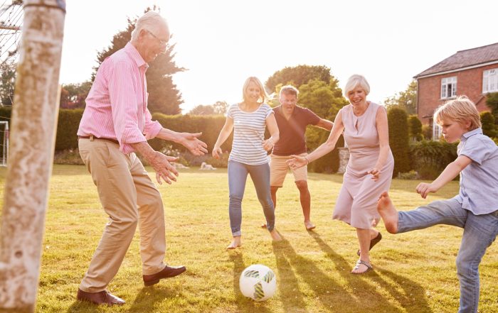 A family playing football in a garden.