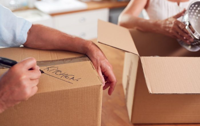 A close-up of a couple packing boxes to move home.