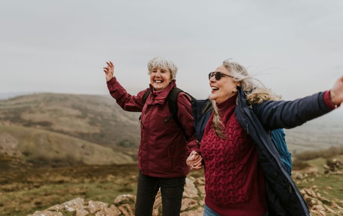 Two women laughing together during a hike.