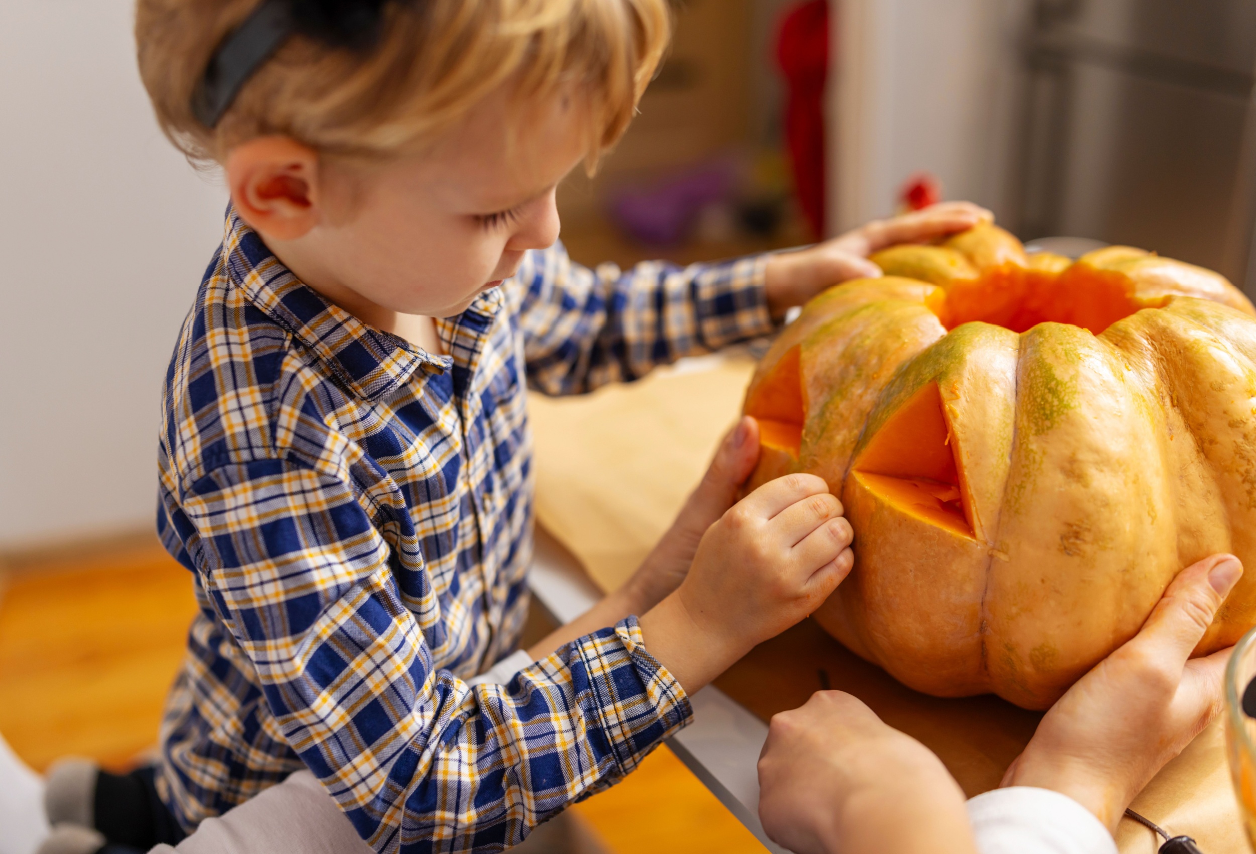 A child carving a pumpkin.