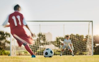 A footballer taking a shot at a goal.