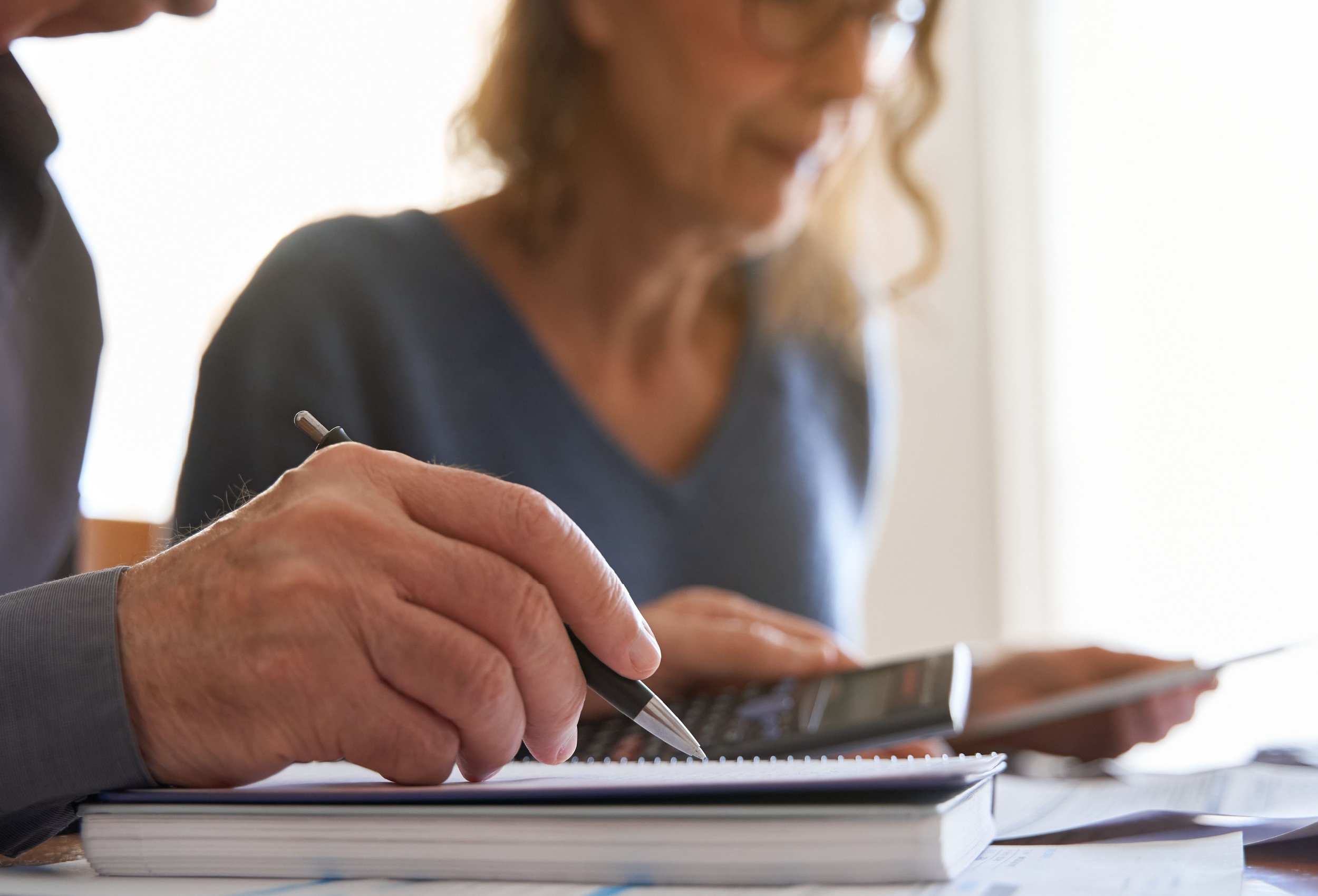 Couple looking at paperwork and using a calculator