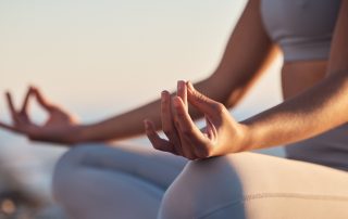 A woman sitting in the lotus position mediating.