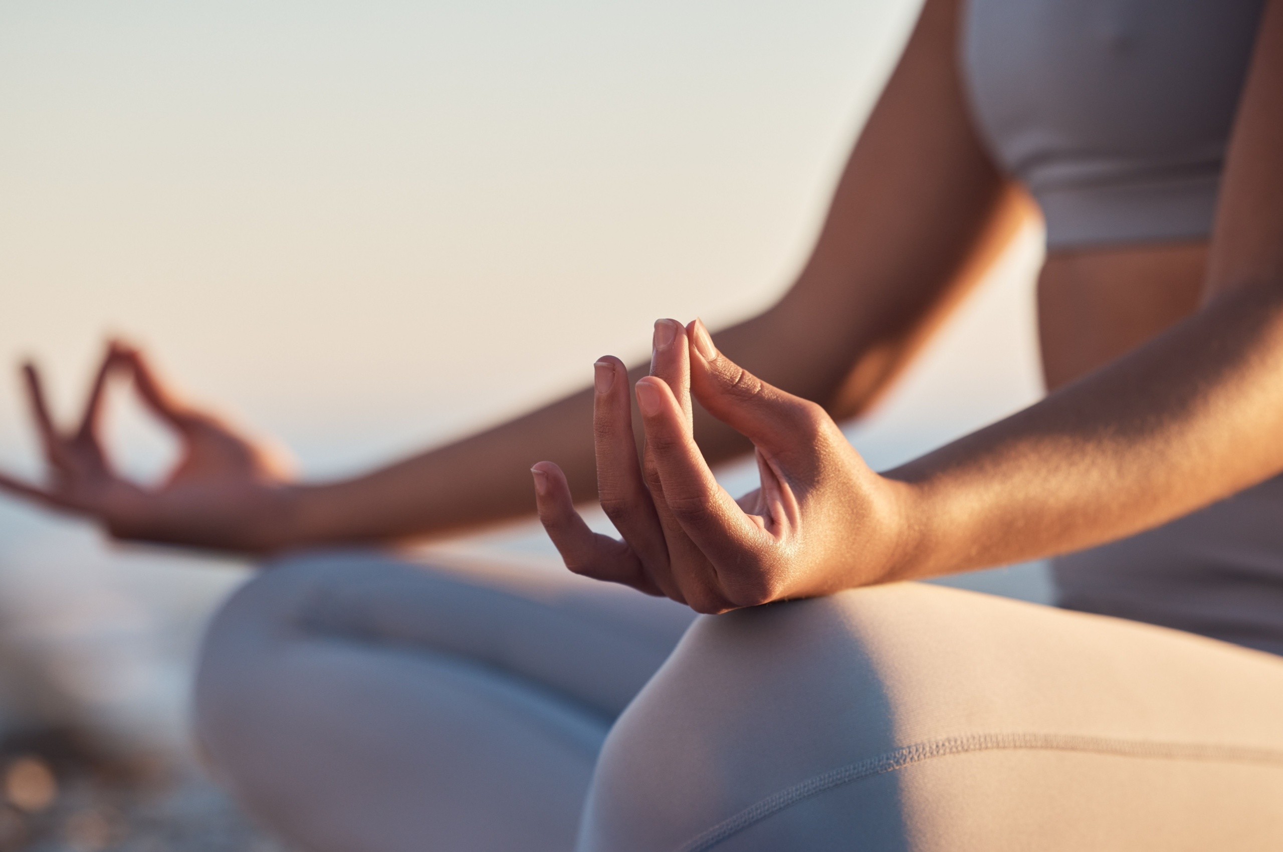 A woman sitting in the lotus position mediating.