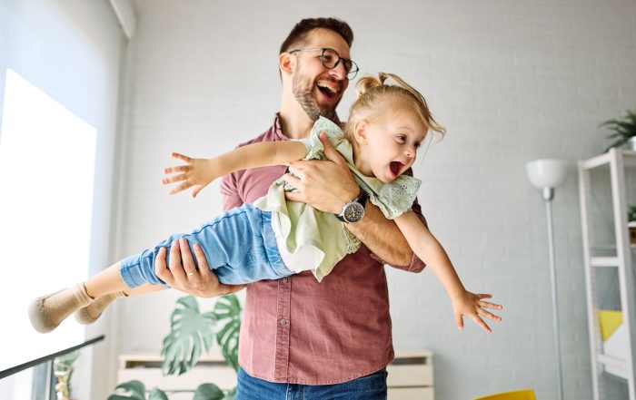 A father playing with his young daughter.