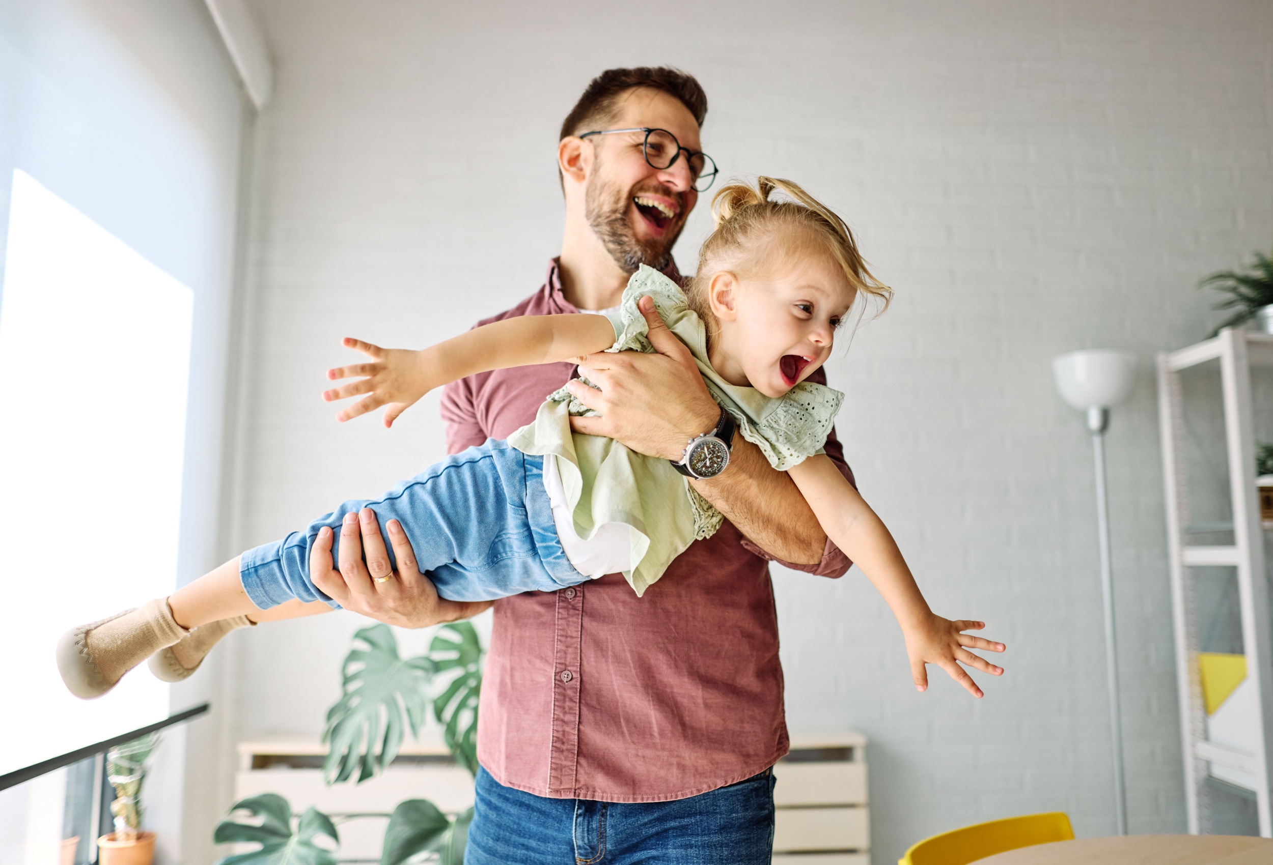 A father playing with his young daughter.
